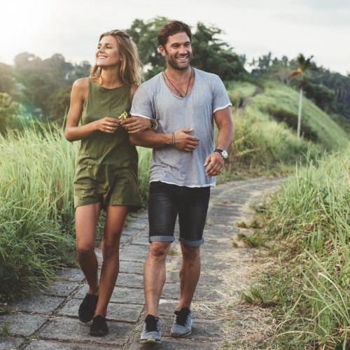 The essence of exceptional living a man and woman walking on a path in a grassy area