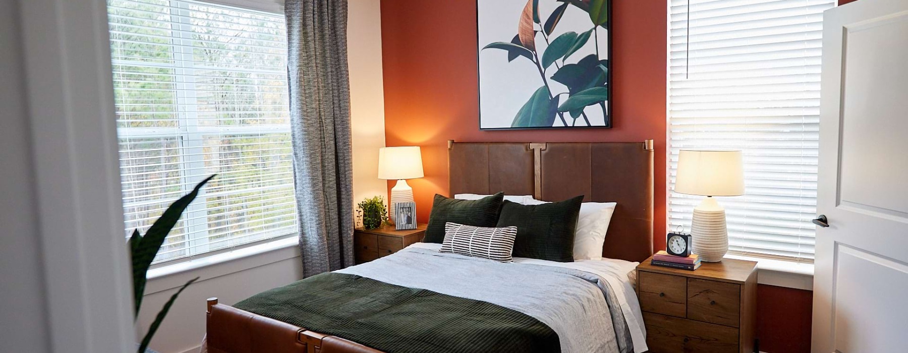 Modeled carpeted bedroom with a ceiling fan and picture windows