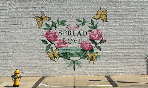 spread love mural on brick wall